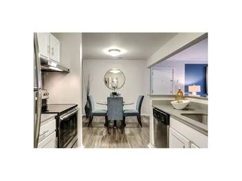 A modern kitchen with a dining table and chairs.